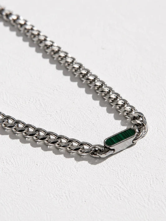 Ravion silver-toned metal chain necklace with a small rectangular green inlay or charm, photographed on a light textured white background.