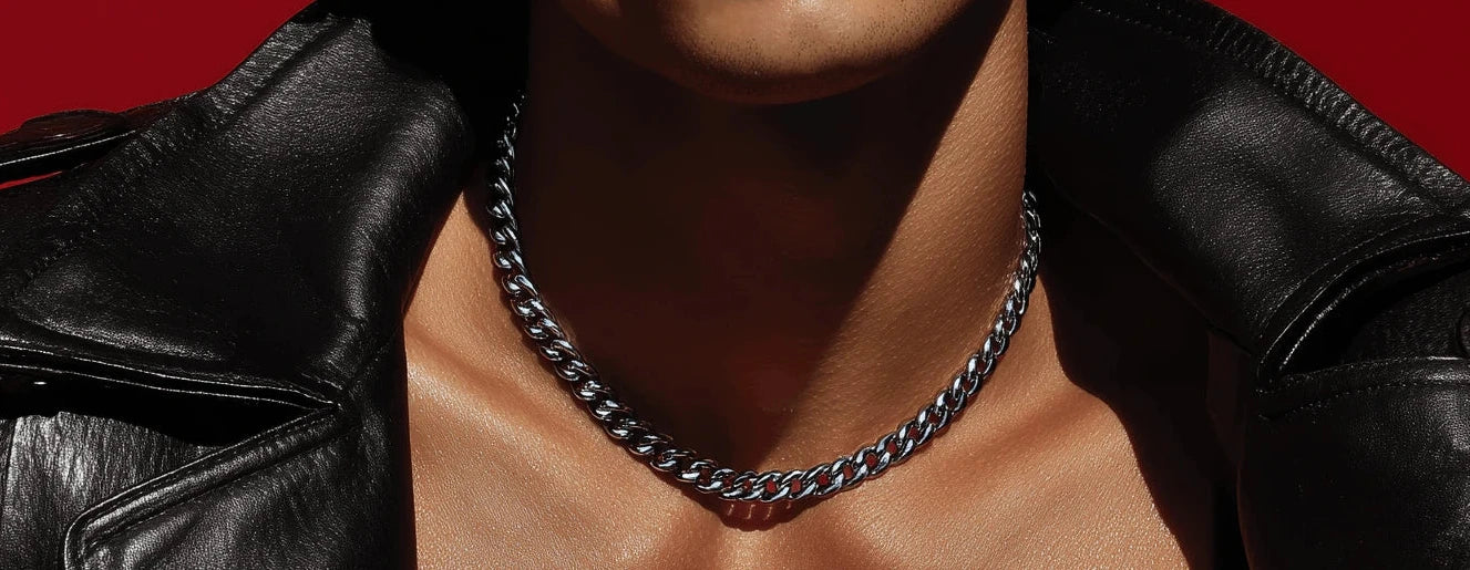 Man wearing a black leather jacket and chain necklace against a red background